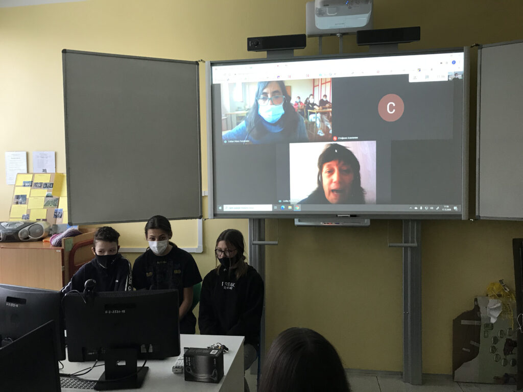 interaktivní tabule a několik žáků u PC